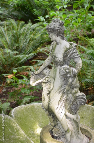 Obraz na plátně Weathered statue of woman in fern garden