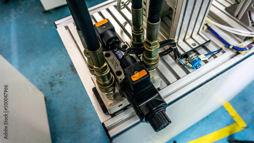Close up view of 4/3 ways Solenoid Operated Directional Valves connected to hydraulic circuit on a industrial electrical hydraulic pressing machine. Selective focus.