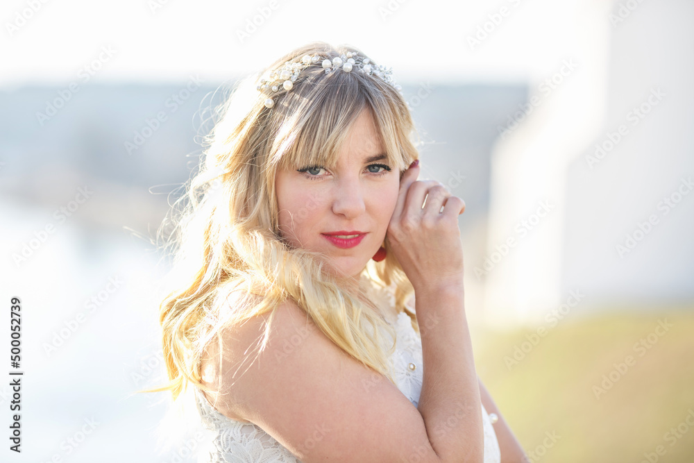 Outdoor close up portrait beautiful blonde girl with youth and skin care attractive looking at camera in white dress. Light key Outdoor close up portrait beautiful blonde girl with youth and skin care attractive looking at camera in white dress. Light key
