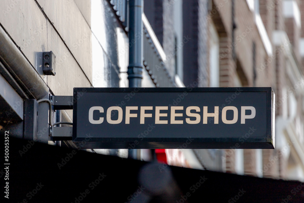 Obraz premium Black electronic light sign with a word COFFEESHOP on the rooftop of the shop in Amsterdam, Coffeeshop is where and can buy or smoking marijuana and weed, Cannabis is legal and accepted in Netherlands