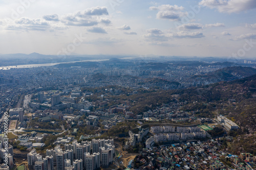 Aerial cityscape of Seoul surrounded by buildings in background of mountains photo