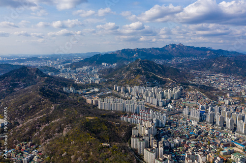 Aerial cityscape of Seoul surrounded by buildings in background of mountains photo