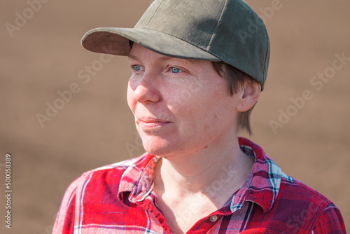 Female farmer with baseball cap and plaid shirt, headshot portrait photo