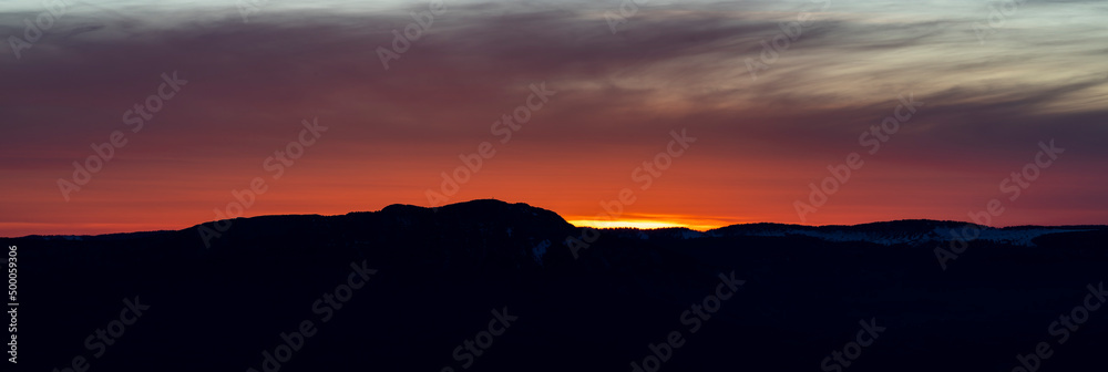 Bright red sunset and mountain silhouette Bright red sunset and mountain silhouette