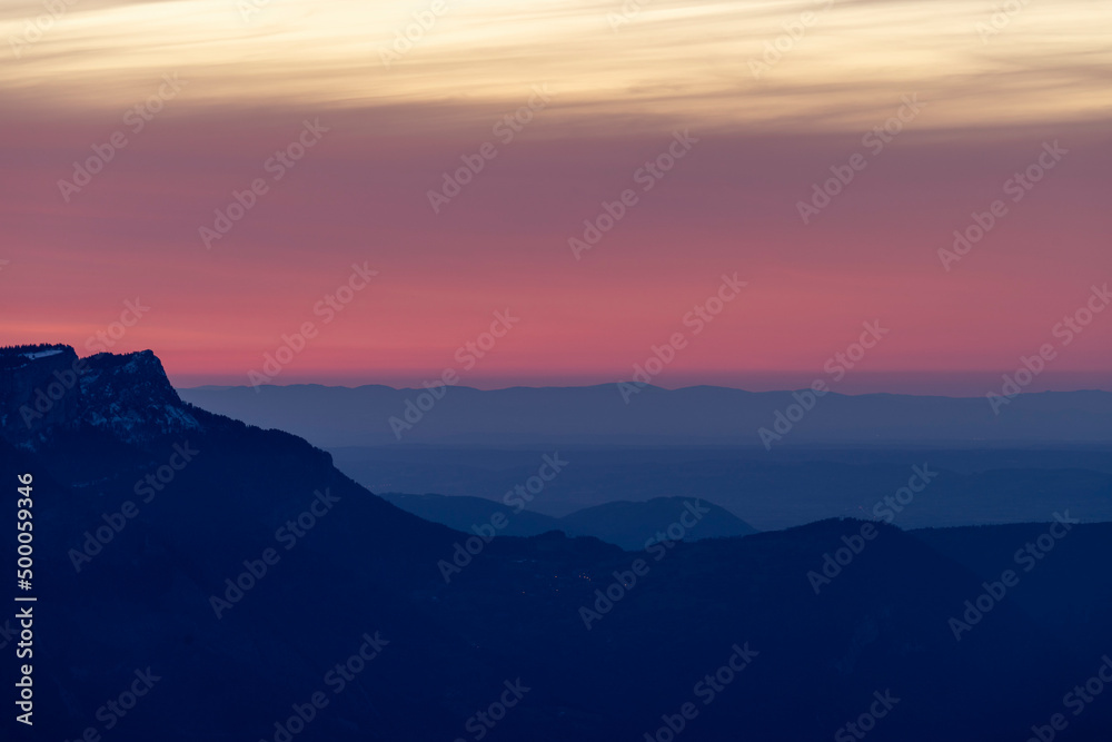 Mountains blue silhouettes during sunset and red clouds
