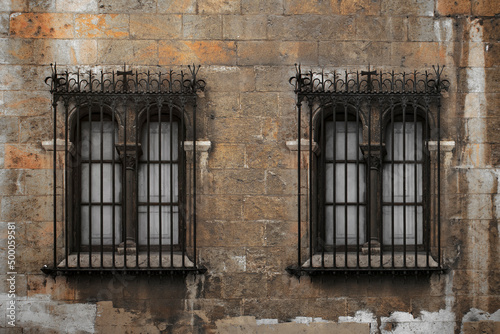 Old vintage windows with bars. Brown brick wall
