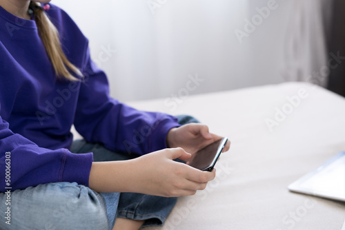 a girl in a purple hoodie plays on the phone