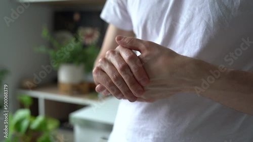 Man massaging herself arm suffering from pain after working on computer at home. Male suffer from carpal tunnel ache. Guy touching painful palm after injury or arthritis. Overwork concept
