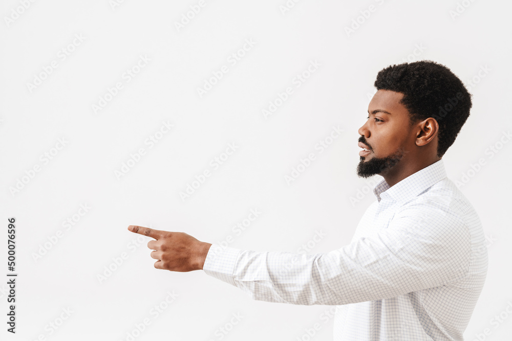 Black mid man wearing shirt looking and pointing finger aside Black mid man wearing shirt looking and pointing finger aside