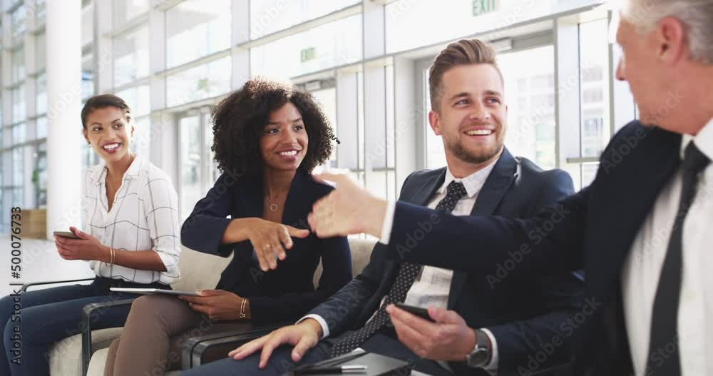 Meeting fellow business delegates. Handsome mature confident caucasian business man and beautiful young multi ethnic business woman shaking hands, greeting while sitting in line in a modern office