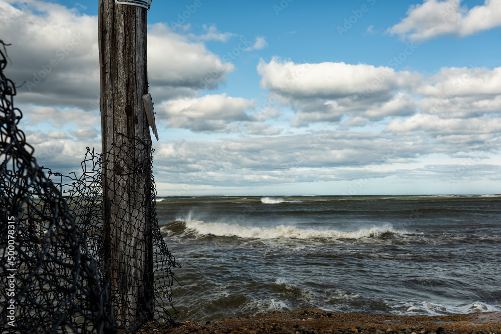 Stormy sea and an old fence on the shore. Atlantic Ocean. USA. Maine.