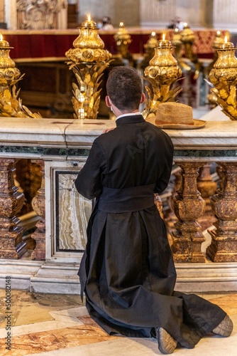 Photographie d'un religieux en pleine prière dans l'église du Vatican à Rome en Italie