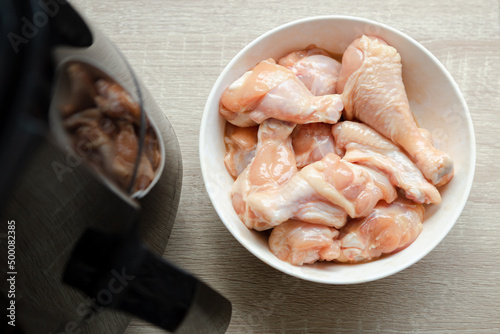 several pieces of chicken drumsticks in a white cup It's about to be fried in an oil-free fryer.