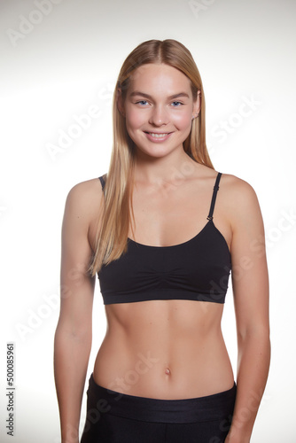 Studio portrait of a young pretty girl with a sporty physique on a studio background.