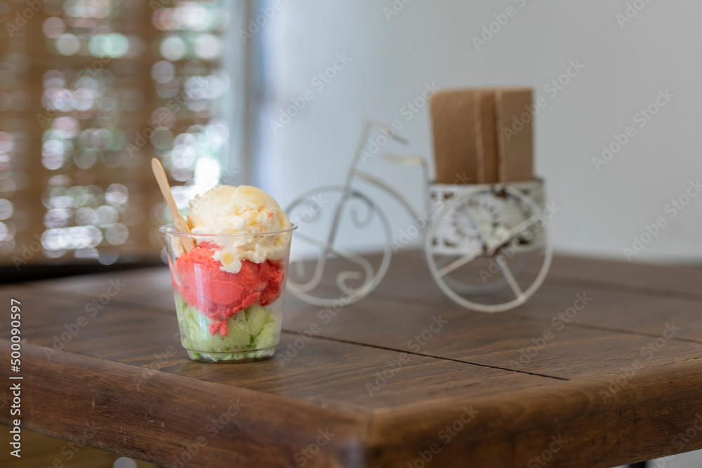 Traditional ice cream of different flavors, served in a glass on a table with copy space