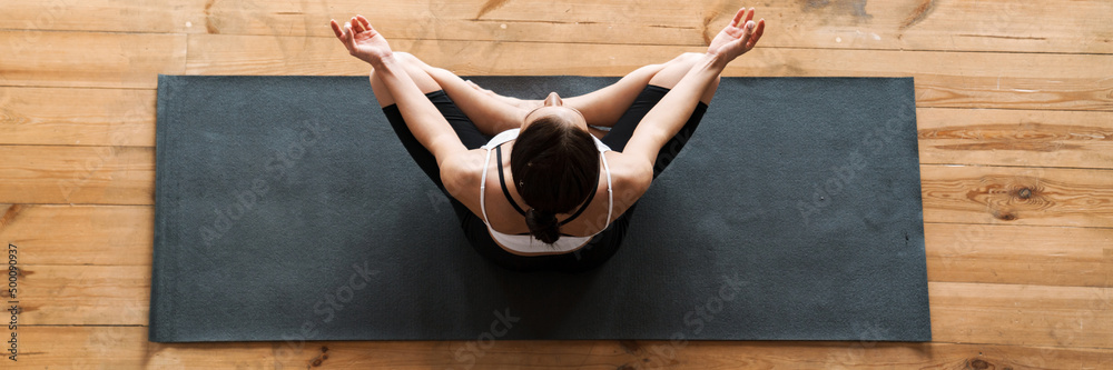 Fototapeta premium Young slim brunette fitness woman stretching