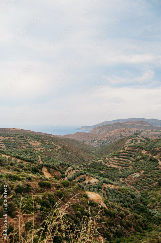 Landscape overlooking mountains and hills, sea on the horizon, Crete, Greece.