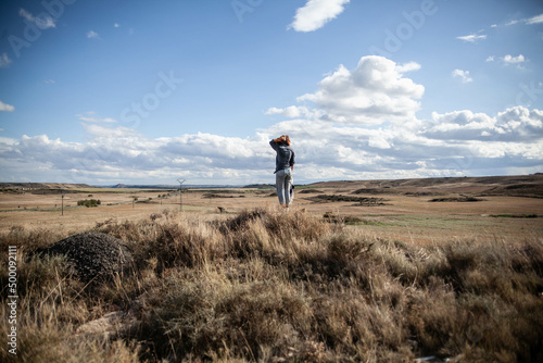 Femme debout devant un paysage de plaines