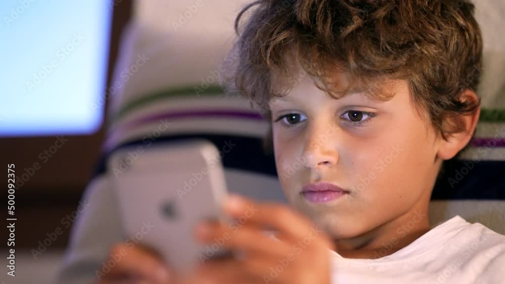 One addicted teenager boy staring at smartphone screen