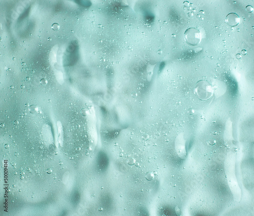 Green transparent gel texture filled with air bubbles. Development of cosmetics. Research in cosmetology.