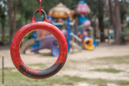 Close up old hanging ring, monkey bar on blur kids park in the afternoon background.