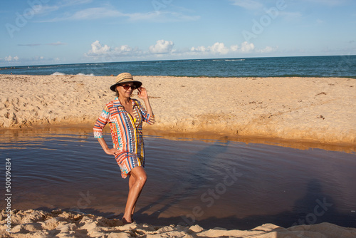 Woman wearing colorful beachwear at the beach known as Pitinga, in Arraial d Ajuda, Bahia, Brazil  photo