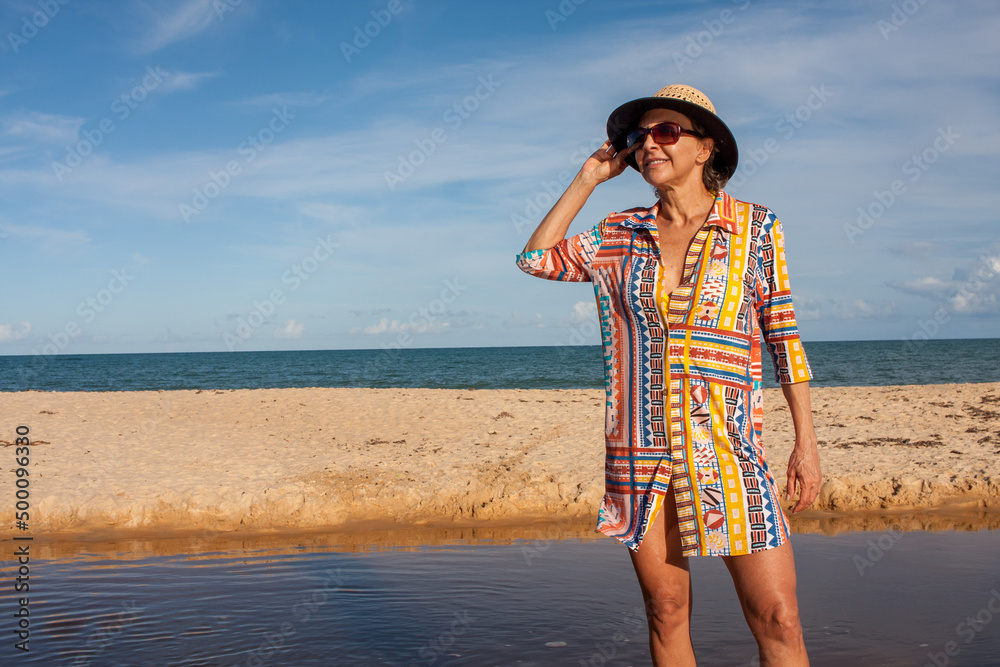 Woman wearing colorful beachwear at the beach known as Pitinga, in Arraial d Ajuda, Bahia, Brazil Woman wearing colorful beachwear at the beach known as Pitinga, in Arraial d Ajuda, Bahia, Brazil