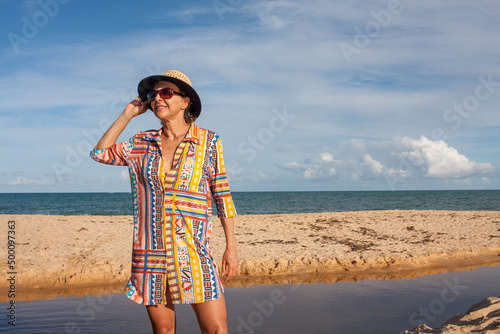 Woman wearing colorful beachwear at the beach known as Pitinga, in Arraial d Ajuda, Bahia, Brazil  photo