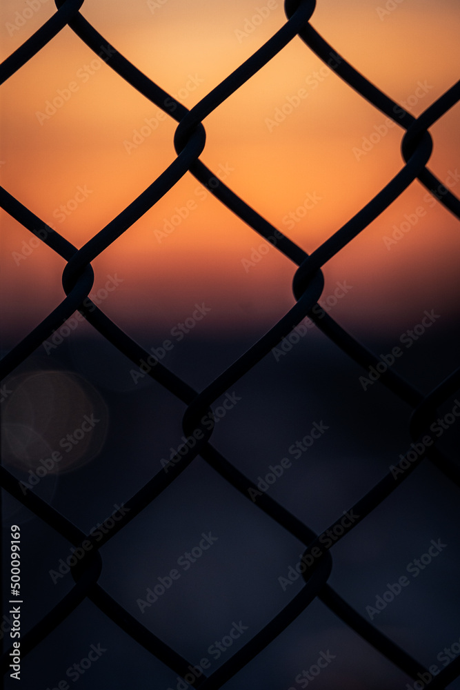 Fototapeta premium Blurry sunset behind a fence