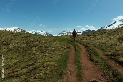 Woman trekking in the Pyrenees approaching the snowy mountains, between Spain and France. near Candanchu photo