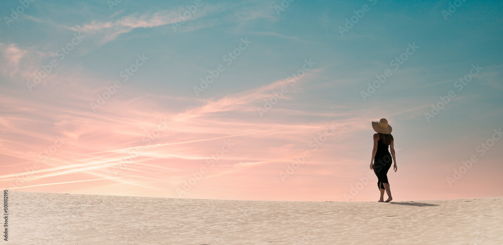 Traveler walking in desert at sunset Traveler walking in desert at sunset