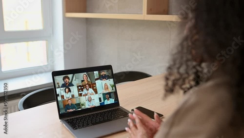 Positive young african-american young woman talking on the distance with a group of diverse multiracial people, brainstorm on the distance with international workteam
