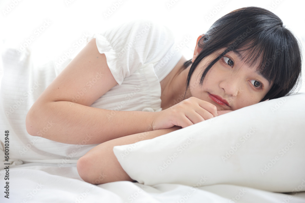 Beautiful young Asian woman sleeping on bed relaxing in the morning light with white room Beautiful young Asian woman sleeping on bed relaxing in the morning light with white room