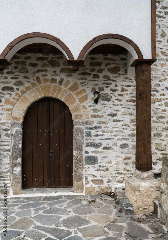 Antique arch and portal of a church with a massive wooden door