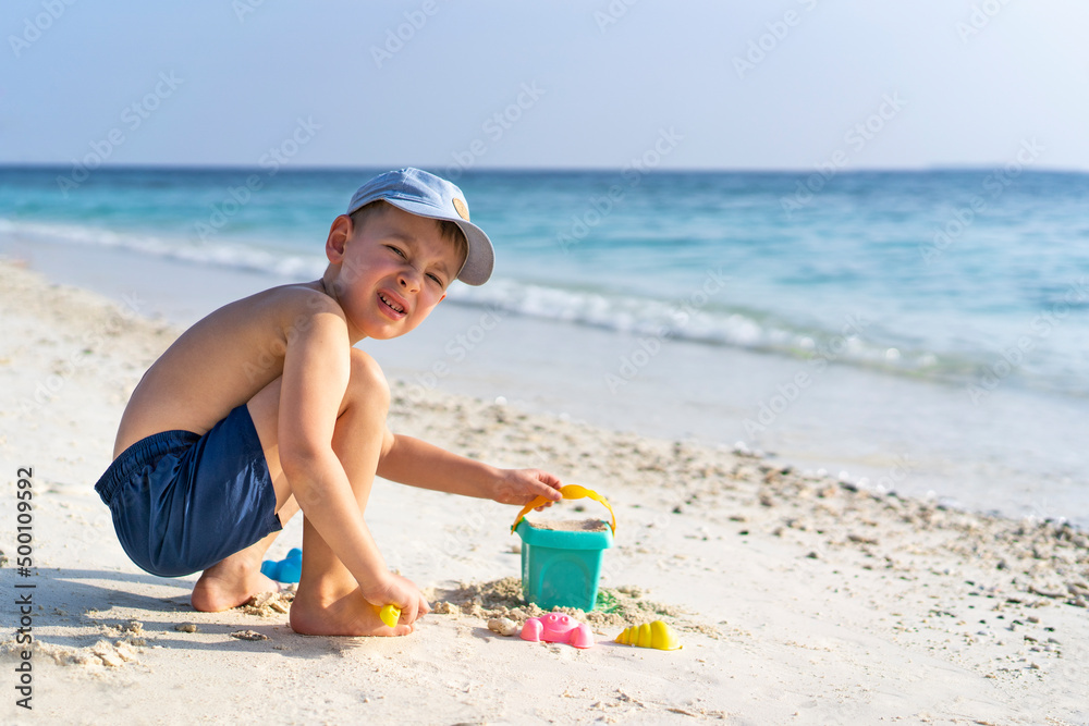 Little boy playing with toys on the seaside. Holidays in Maldives Little boy playing with toys on the seaside. Holidays in Maldives