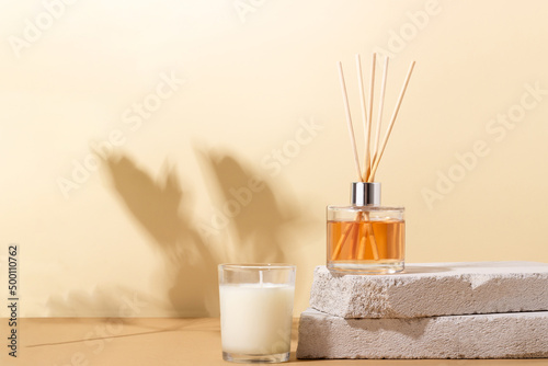 reed diffuser bottle on the podium. Incense sticks for the home with a floral scent with hard shadows. The concept of eco-friendly fragrance for the home