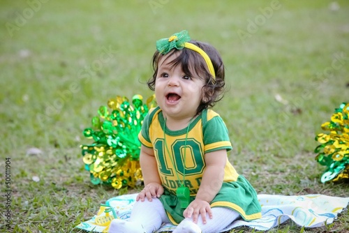 Linda criança torcedora do brasil num parque fantasiada de verde e amarelo. photo
