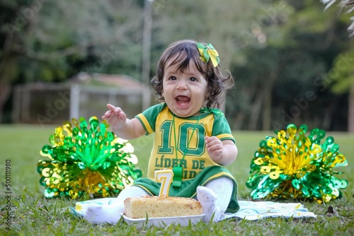 Linda criança torcedora do brasil num parque fantasiada de verde e amarelo. photo