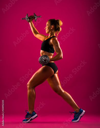 Athletic young woman doing a fitness workout with weights, isolated on red background 