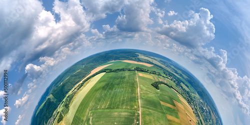 Fototapeta Naklejka Na Ścianę i Meble -  Aerial view from high altitude of little planet earth with green and yellow cultivated agricultural fields with growing crops on bright summer day