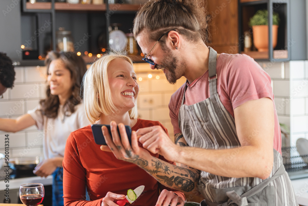 Young diverse people having a home party, preparing food, drinking, having fun Young diverse people having a home party, preparing food, drinking, having fun