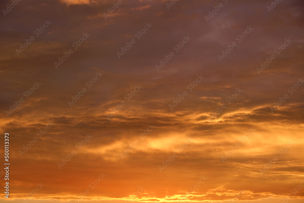 Bright colorful sunset sky with rays of setting sun and vivid dark clouds