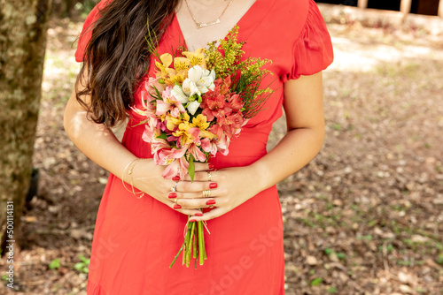 Woman in a red dress holding a bouquet of flowers