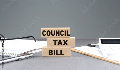COUNCILTAX BILL text on wooden block with notebook,chart and calculator, grey background photo