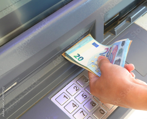 фотографія atm and banknotes in euros and the hand