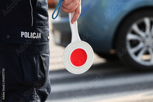 Policjant policji drogowej podczas kierowania ruchem z lizakiem do zatrzymywania pojazdów. photo