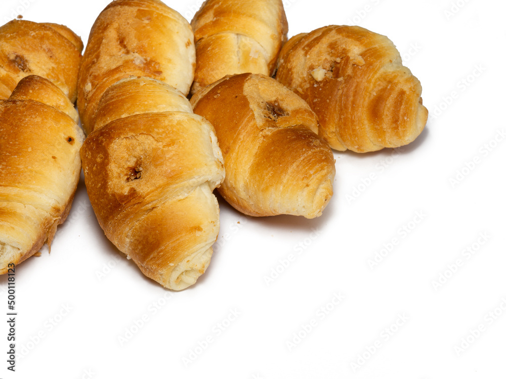 Many small croissants on a white background. Croissants with boiled condensed milk. Confectionery in the kitchen.