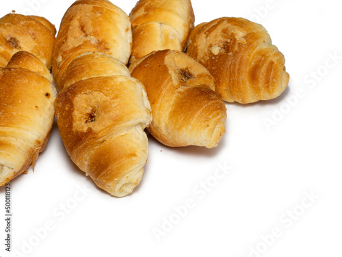 Many small croissants on a white background. Croissants with boiled condensed milk. Confectionery in the kitchen.