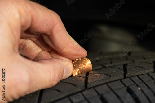Checking tread depth on a tire by using a penny photo