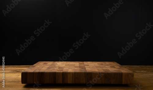 Wooden board for cutting on a black background.